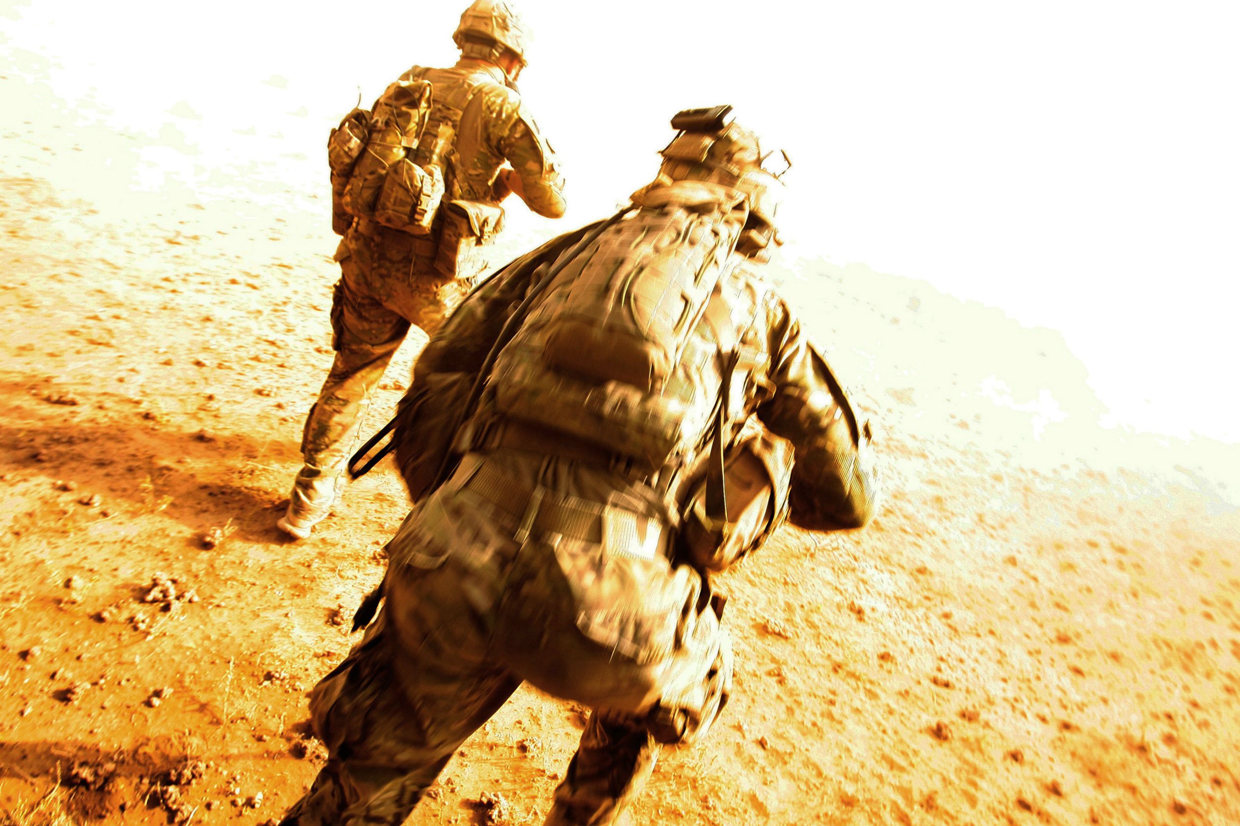 Spc. Lynn Schell, left, and Staff Sgt. Donald Thompson, both Pathfinders with 4th Battalion, 101st Aviation Regiment, 159th Combat Aviation Brigade, 101st Airborne Division, run from their Black Hawk helicopter after being dropped in the Registan Desert for a mission on October 4, 2011 in Kandahar province, Afghanistan.  101st Airborne Division Pathfinders