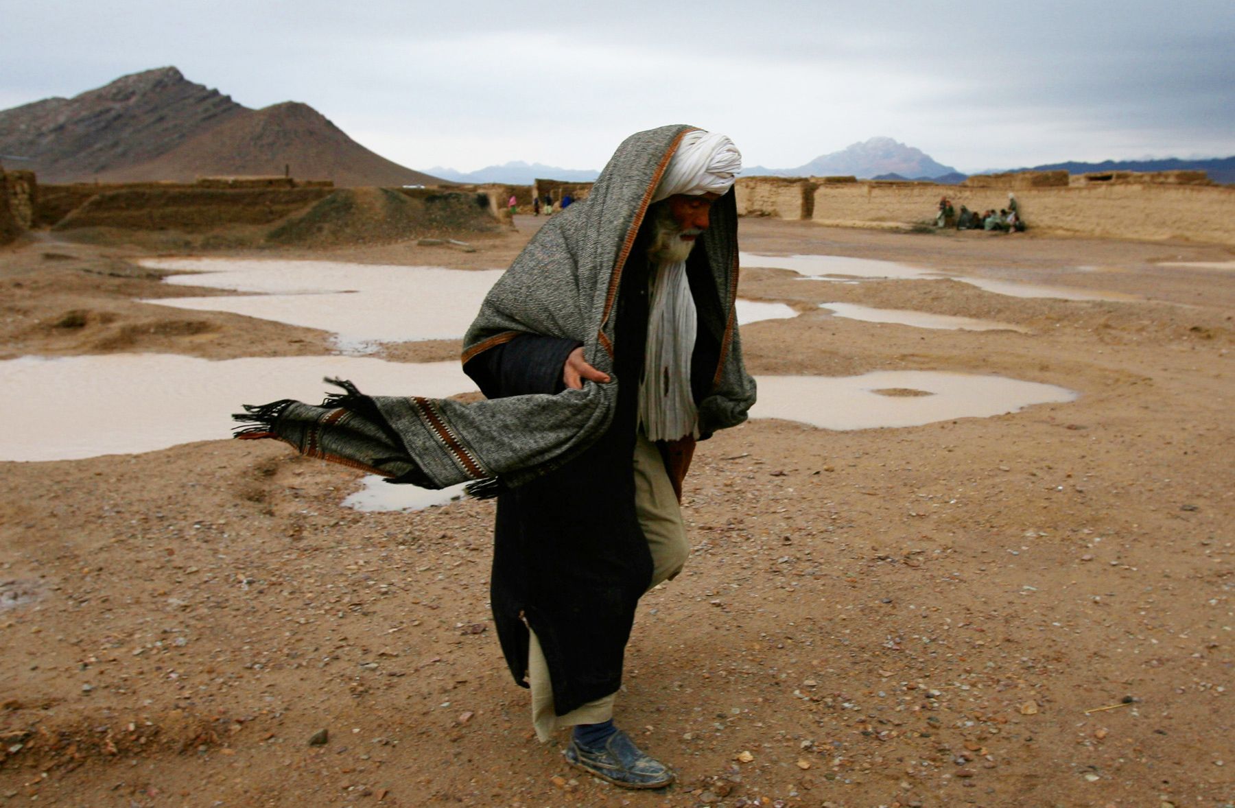 A village elder walks over sodden winter ground on February 18, 2012 in the Zharay Dasht Internally Displaced Persons Camp, in Kandahar Province Afghanistan.  Afghanistan Zharay Dasht