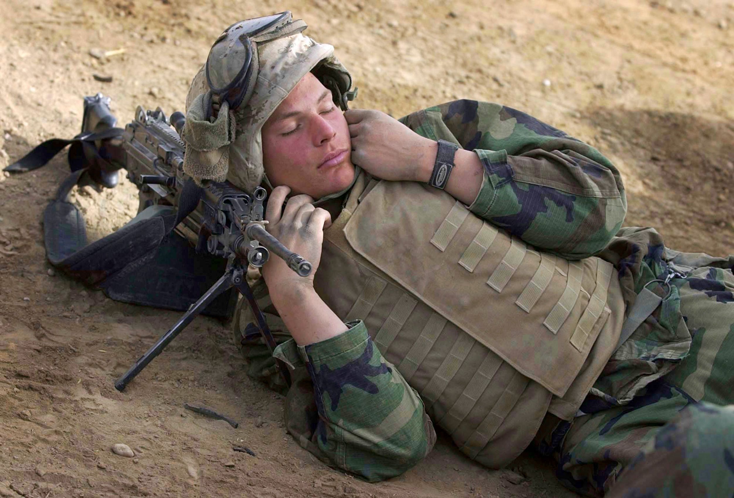 Lcpl. Jerod Powell of Springfied, Mo, with India Co., 3rd Batt.. 7th Marines, 1st Marine Division, sleeps on his automatic weapon while his convoy makes stops on a road just south of Baghdad on Saturday, April 5, 2003. Invasion of Iraq