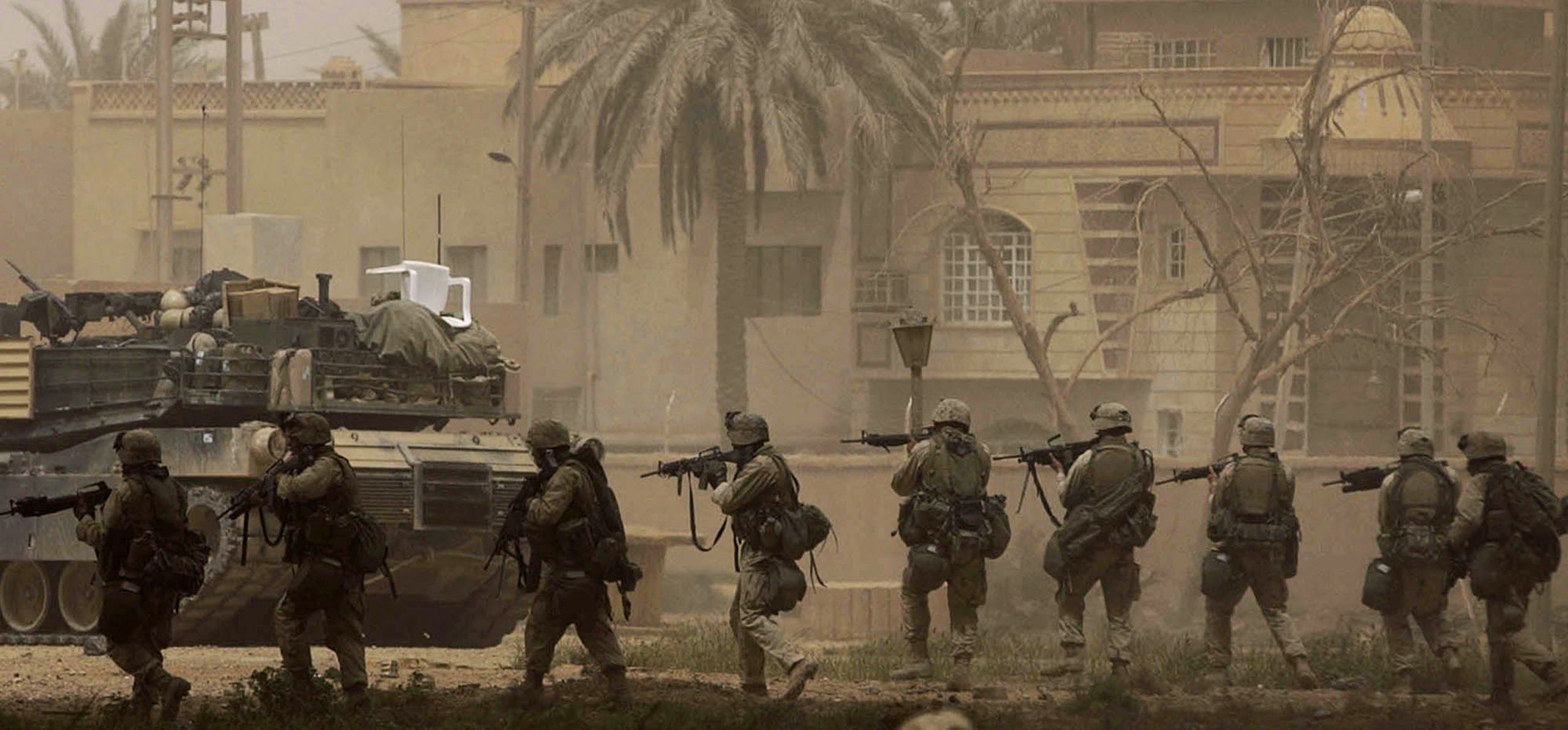 Marines with India Co., 3rd Batt., 7th Marines, 1st Marine Division, advance on the headquarters of the Fidaeen in Baghdad on Wednesday, April 9, 2003. The Fidaeen are a secret fighting force controlled by Saddam Hussein.  Invasion of Iraq