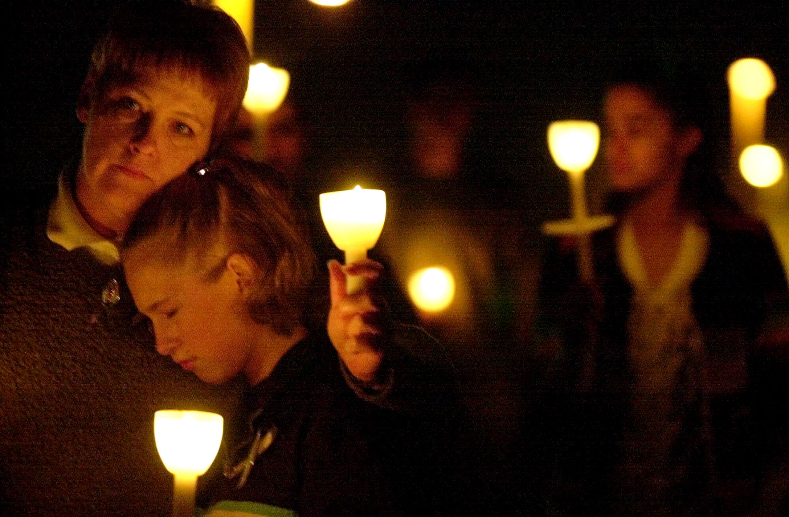 Whitney Wilson, 15, right, leans on her mother Debbie Wilson during a candlelight vigil Thursday, April 20, 2000, for the victims of last year's  Columbine High School shootings in Littleton, Colo.  Columbine Shootings
