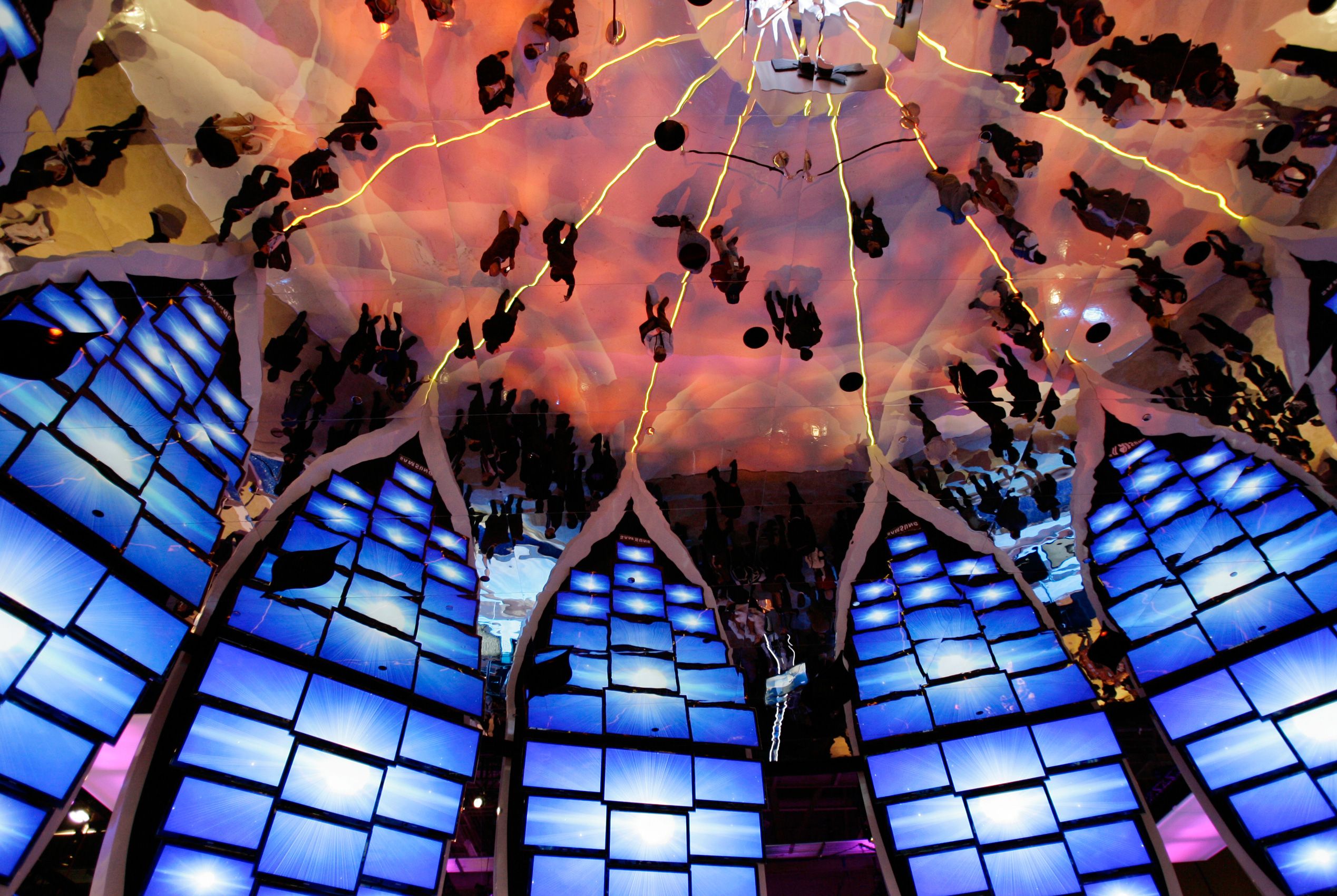 Convention goers and television screens are reflected in the ceiling of the Samsung booth at the International Consumer Electronics Show (CES) in Las Vegas on Thursday, Jan. 7, 2010. Consumer Electronics Show Las Vegas