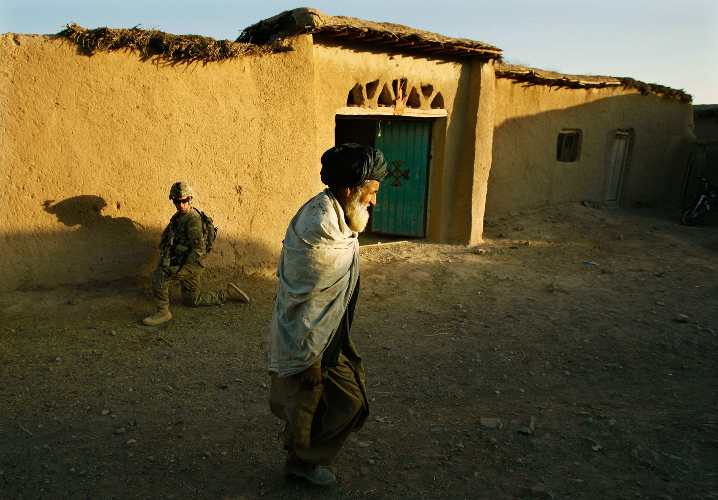Pfc. Brian Silva, of Company F, 4th Battalion, 101st Aviation Regiment, 159th Combat Aviation Brigade, 101st Airborne Division, kneels  while patrolling the village of Loy Shur with Afghan National Army soldiers on September 23, 2011 in Zabul province, Afghanistan.  101st Airborne Division Pathfinders