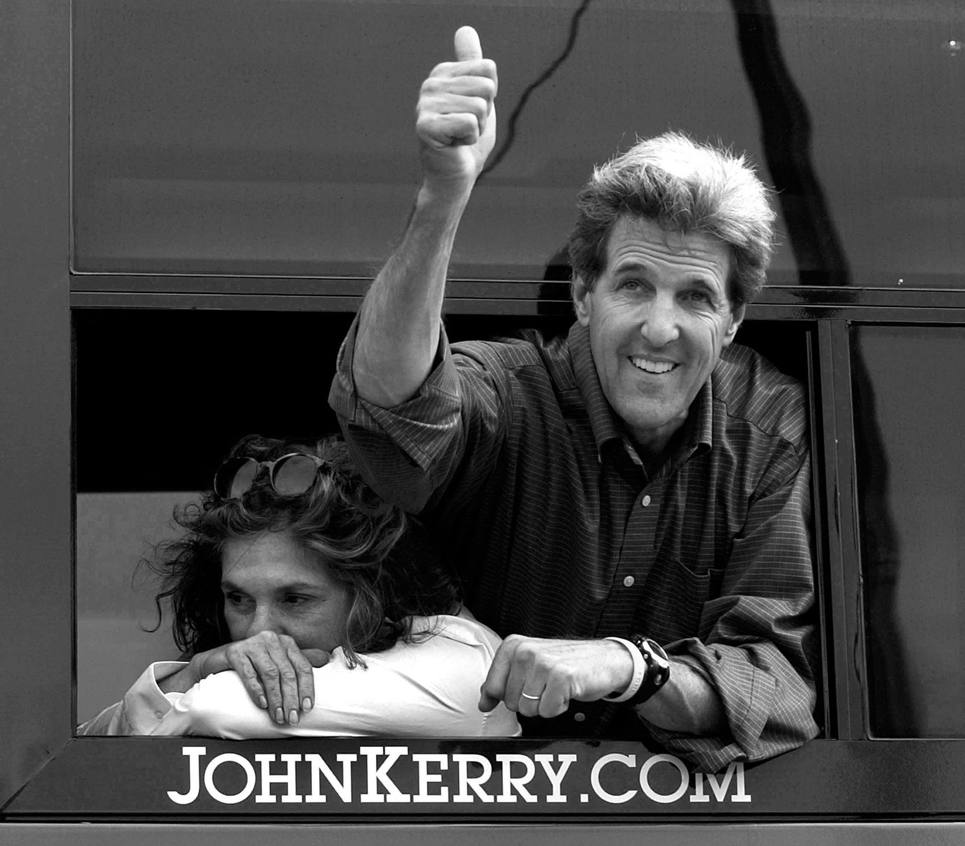 Democratic presidential nominee Sen. John Kerry, D-Mass., waves to supporters as his wife, Teresa Heinz Kerry rests on the window sill of their campaign bus in Fort Madison, Iowa on Wednesday, Aug. 4, 2004.  John Kerry Presidential Campaign 2004