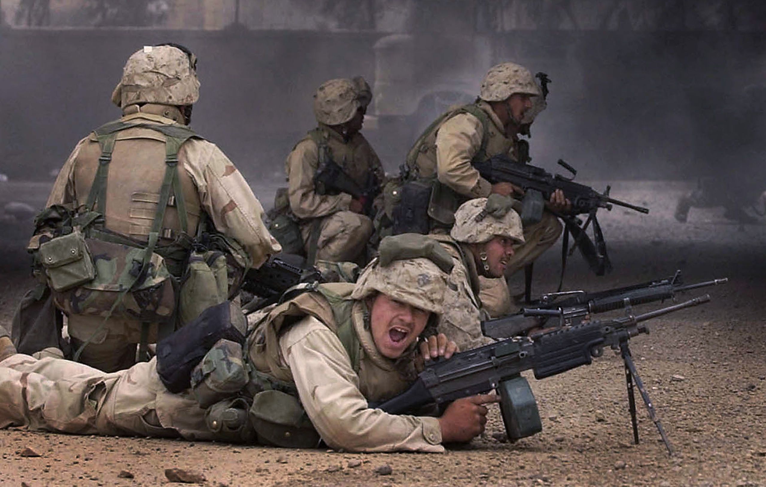 Marines with India Co., 3rd Batt., 7th Marines, 1st Marine Division, provides cover fire as other Marines advance on the headquarters of the Fidaeen in Baghdad on Wednesday, April 9, 2003. The Fidaeen are a secret fighting force controlled by Saddam Hussein. Invasion of Iraq