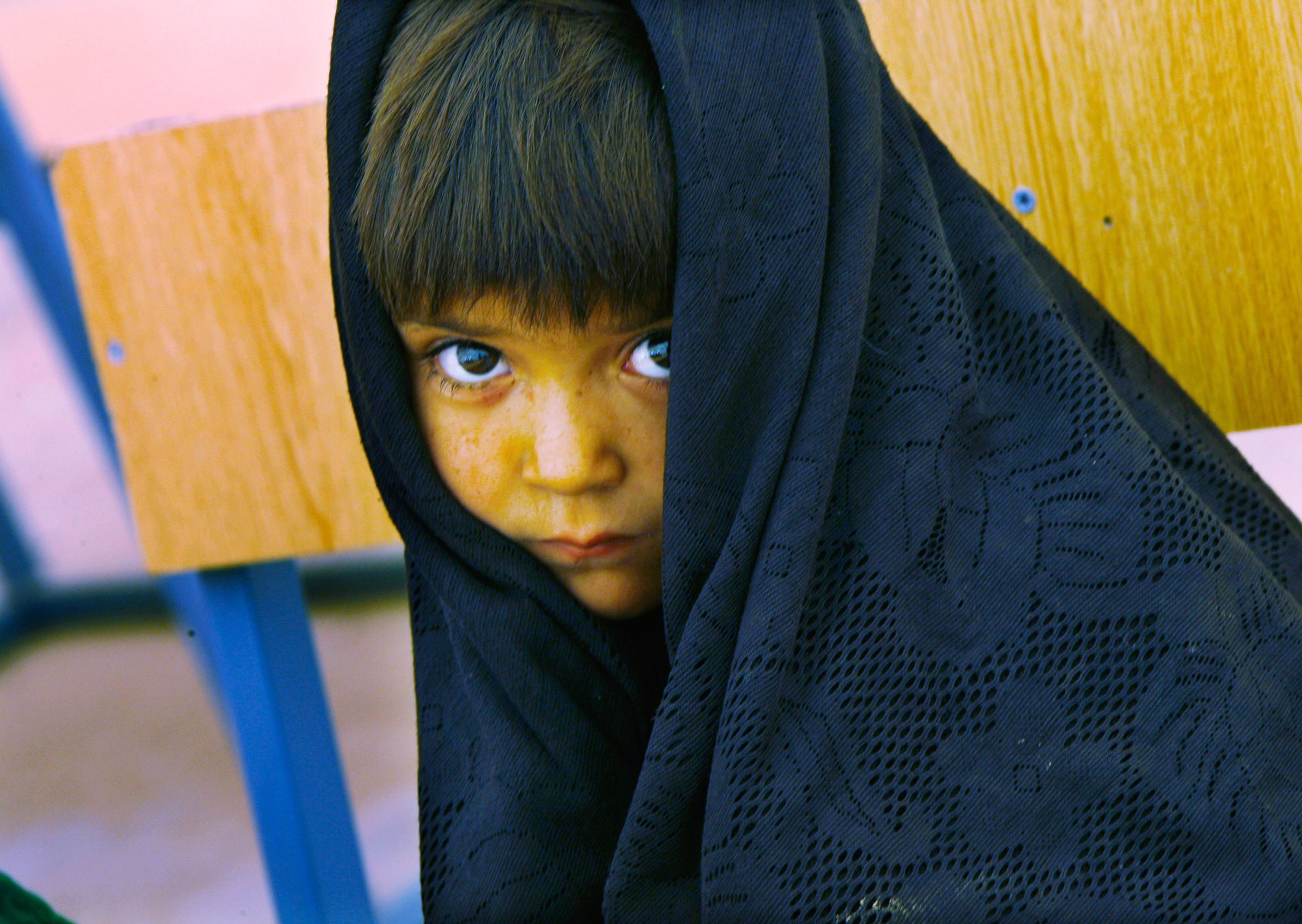A young female student looks up from her desk at a school in the Zhari Dasht internally displaced persons camp on September 7, 2011 in Kandahar Province, Afghanistan. Eight schools opened in September in the Zhari and Maiwand districts, two of them to girls.  Zhari Dasht Afghanistan