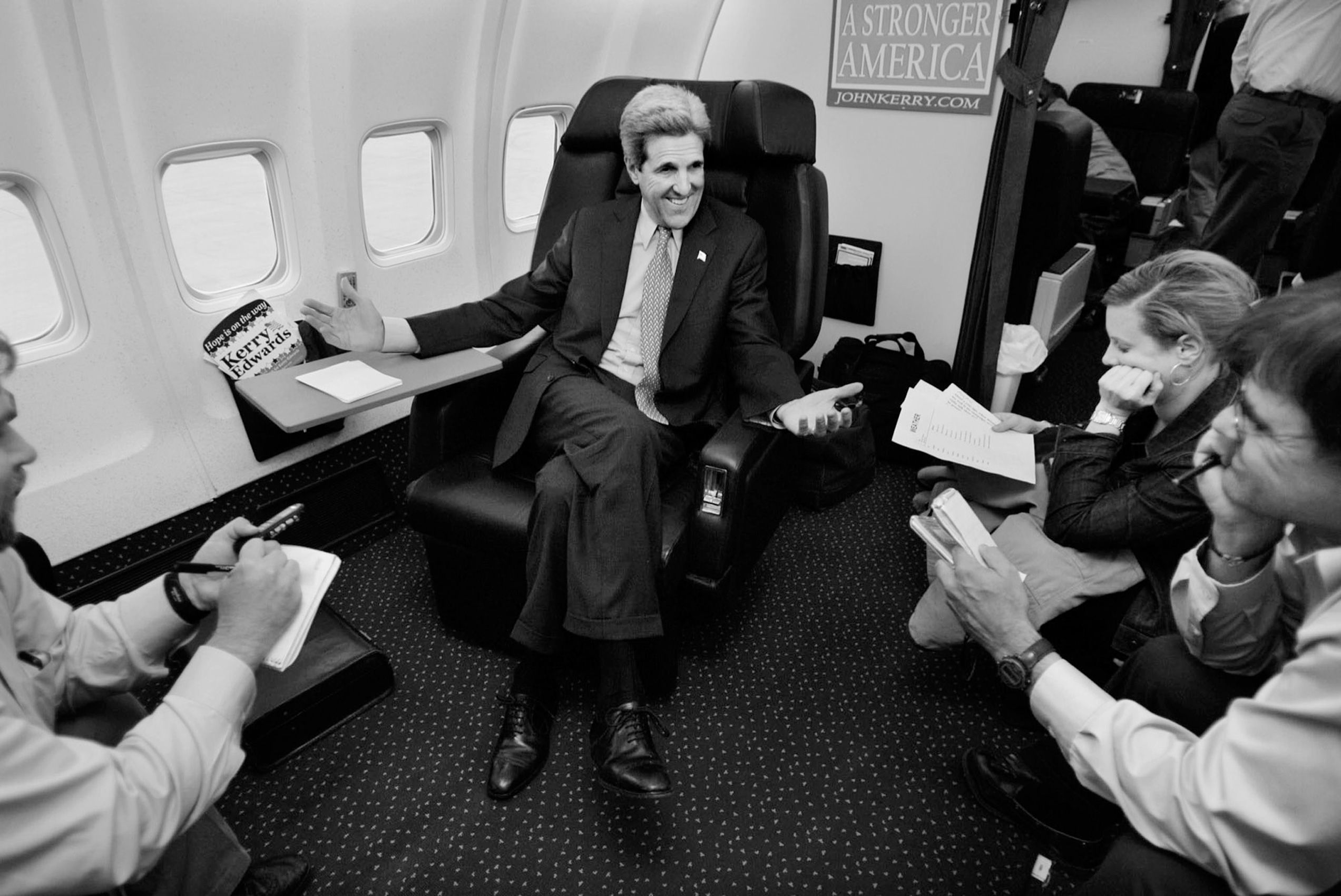 Democratic presidential candidate Sen. John Kerry, D-Mass., talks with reporters and staff members on his campaign plane in Miami on Friday, Oct. 29, 2004. John Kerry Presidential Campaign 2004
