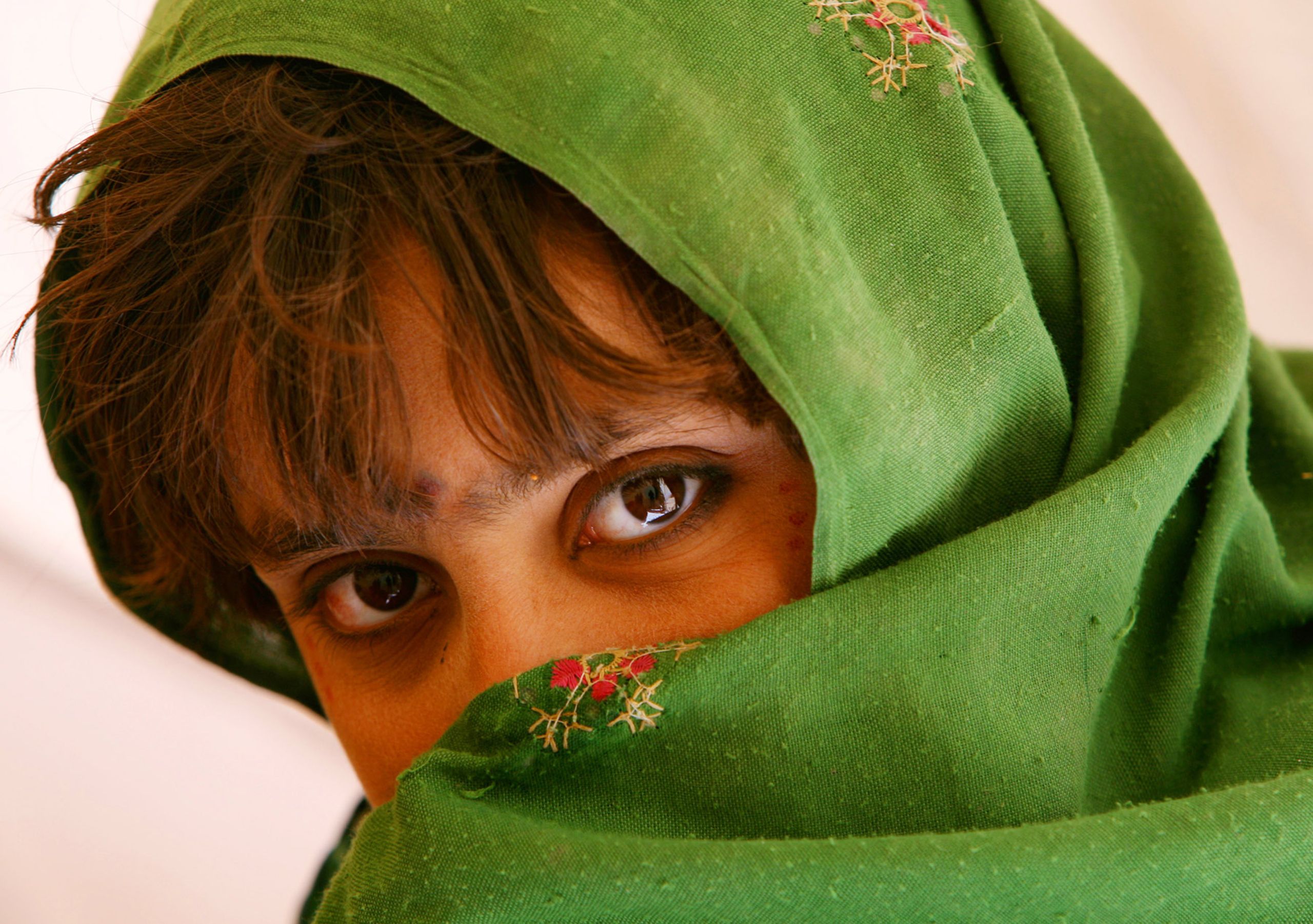 A young girl pauses during a lesson while attending school on February 15, 2012 in the Zharay Dasht Internally Displaced Persons Camp, in Kandahar Province Afghanistan.  Afghanistan Zharay Dasht school