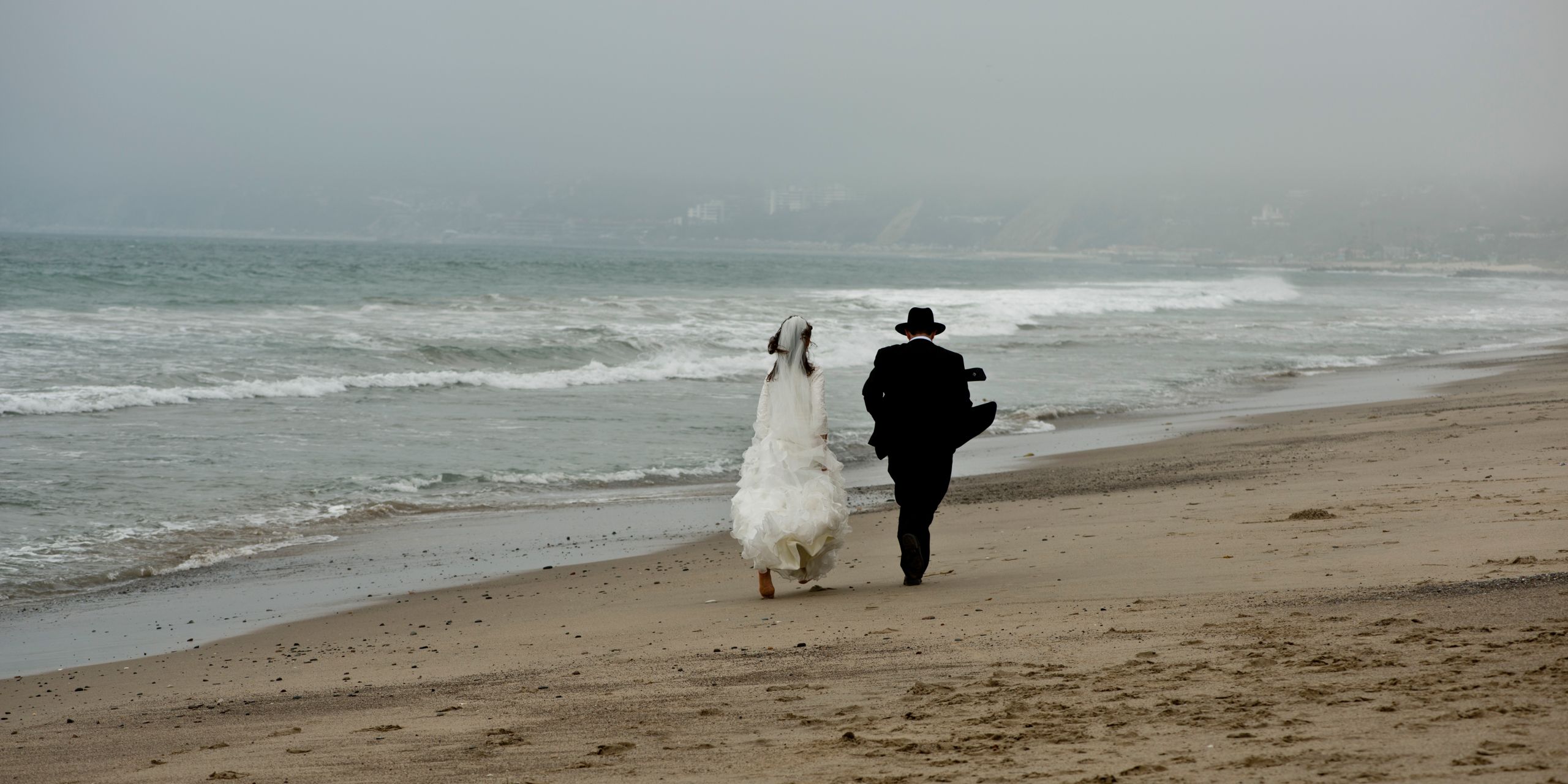 Running along Malibu Beach after the Magic of the Wedding Day