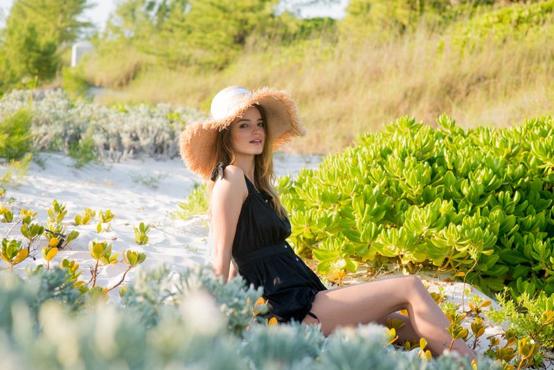 A woman in a sun hat among coastal greenery for Wiggy Kit