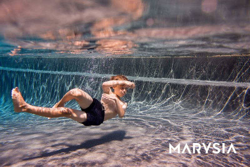 A boy swimming underwater for a children's swimwear campaign