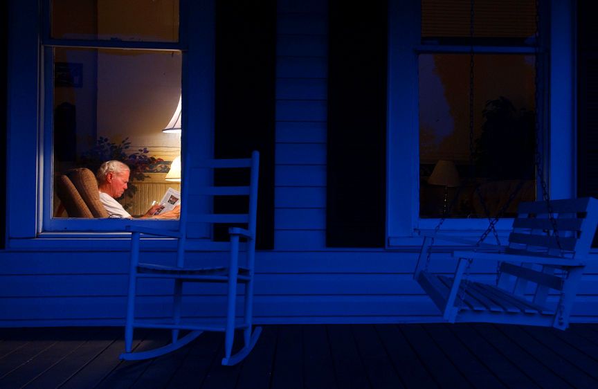 Howard “Curly” Borders, 70, enjoys a good read inside the 90-year-old Pinehurst, GA. home that he and his wife restored. EVENING LIGHT