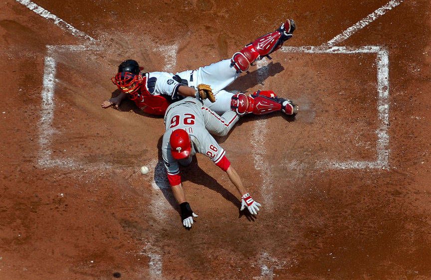 Philadelphia's Chase Utley scores against the Braves Brian McCann. SAFE AT HOME