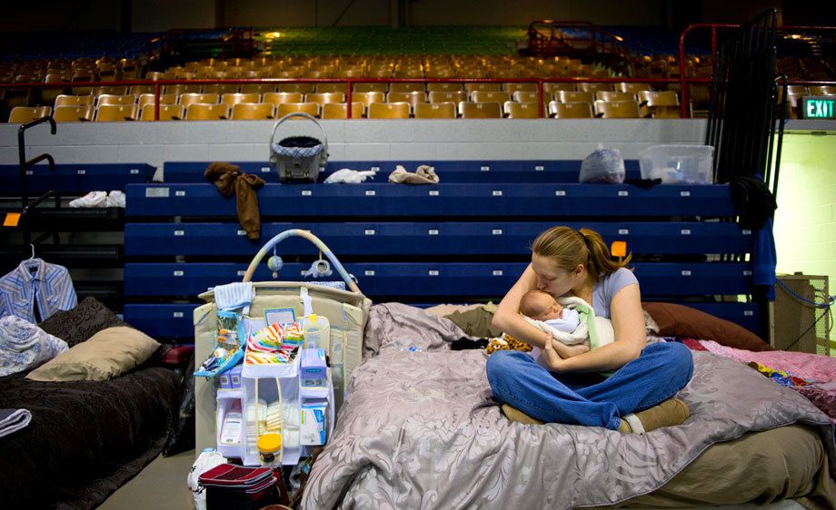 April Moses gives her two-week-old son, Alex, a kiss at the Red Cross shelter in Minot, ND after being forced from her home due to the rising Souris River. Photographed for the New York Times. SHELTER FROM THE STORM