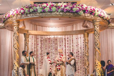 Indian, southasian wedding ceremony decor with gold mandap and custom backdrop Indian wedding ceremony with gold mandap
