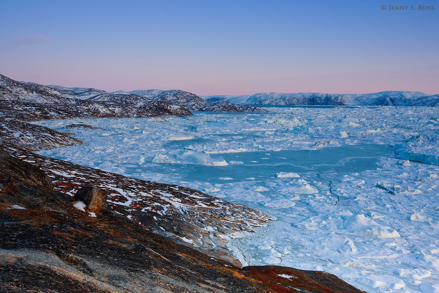 The Ilulissat Icefjord (also known as Ilulissat Kangerlua or Kangia) in West Greenland, bordered by lichen-encrusted rocky slopes.
