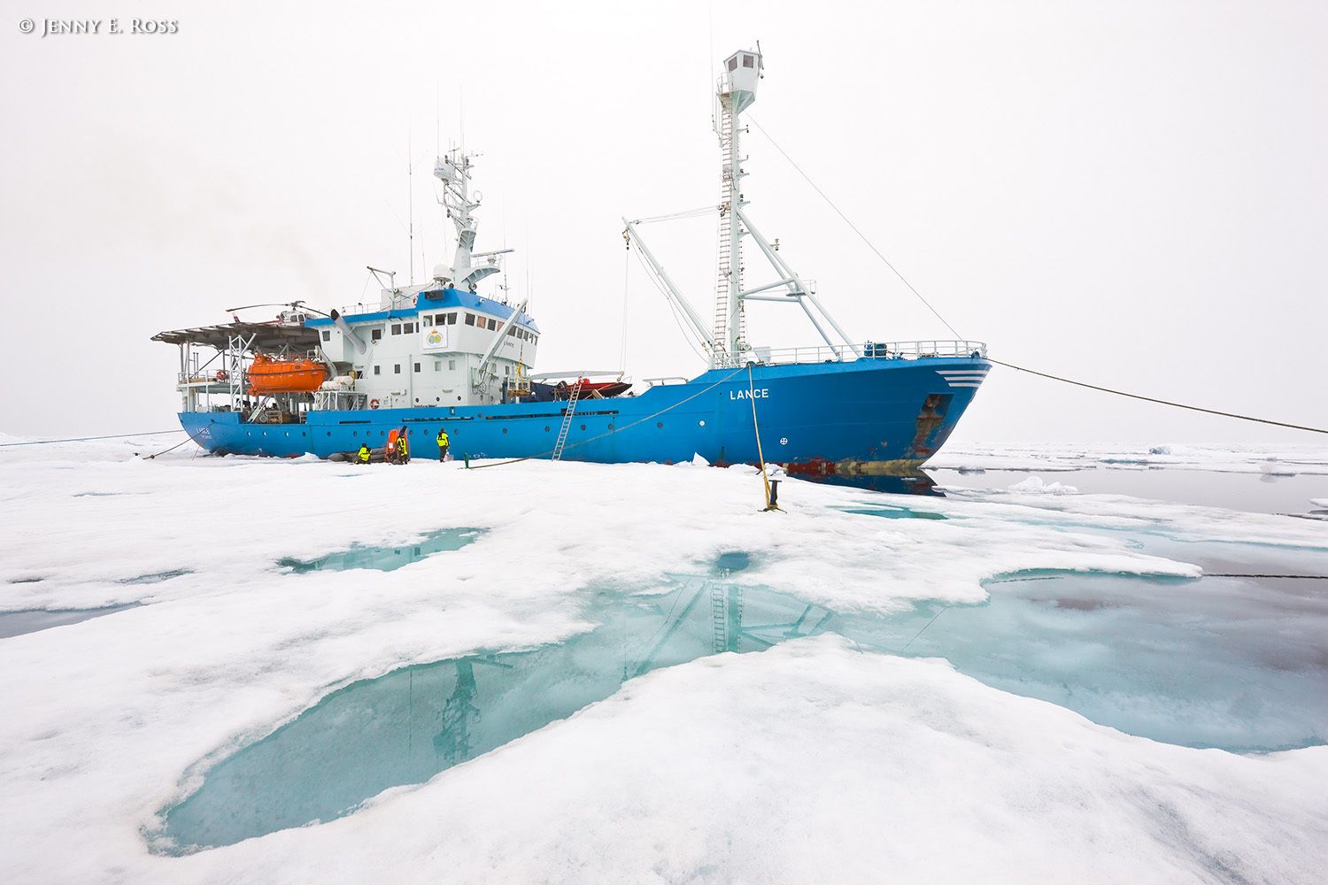 Participants in the Norwegian Polar Institute's 2012 "ICE" ("Ice, Climate, and Ecosystems") scientific research voyage in the Arctic Ocean load scientific equipment onto the NPI ship RV Lance from a large floe of Arctic sea ice where research activities were conducted in July-August 2012. The ship was attached securely to this particular floe of ice, and moved with the floe as it floated freely in the ocean, for the duration of the work. By the end of the scientists' time on the ice, the floe had melted significantly and was obviously deteriorating. Some of the melt ponds on the surface of the ice, such as some shown in this photographs, had melted through completely to the ocean water below. The Arctic Ocean was approximately 3500 meters deep at this location. Scientific research on arctic sea ice, central polar basin, Arctic Ocean