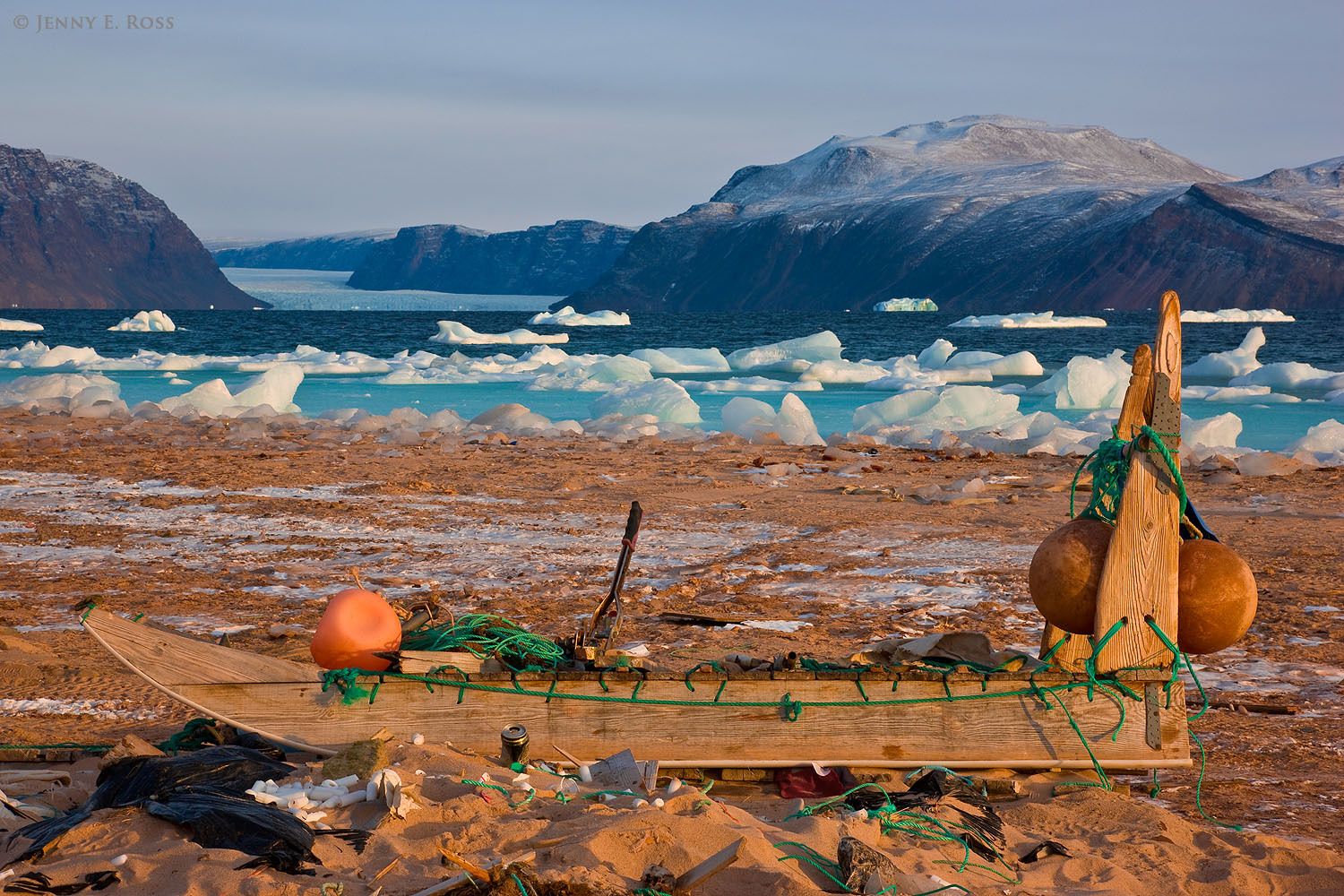 An Inuit sledge (dogsled), used for hunting with dog teams on the sea ice, lies idle near the shoreline of the unfrozen sea in Siorapaluk, Northwest Greenland.
