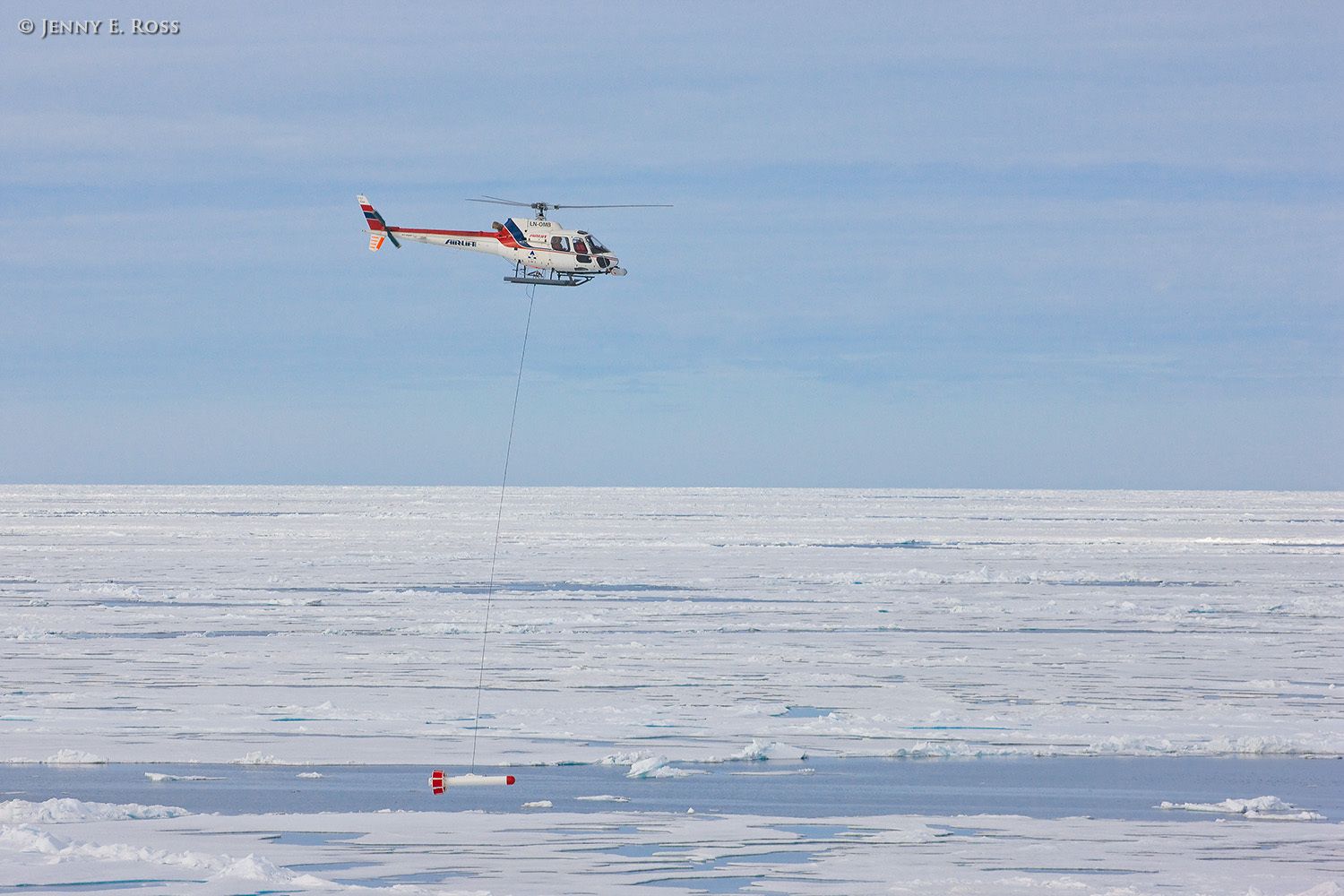 During a research expedition n the Arctic Ocean, Norwegian Polar Institute scientists assess sea ice thickness using an airborne instrument called the EM-Bird, a large torpedo-shaped scientific devicethat hangs from a helicopter. As the helicopter flies transects above the sea ice, the electromagnetic and laser sensors in the EM-Bird collect data that can then used to calculate the thickness of the ice. This work was conducted near 82.5-degrees North / 21-degrees East as part of NPI's 2012 "ICE" (Ice, Climate, and Ecosystems) expedition in July-August 2012. Scientific research on arctic sea ice, central polar basin, Arctic Ocean