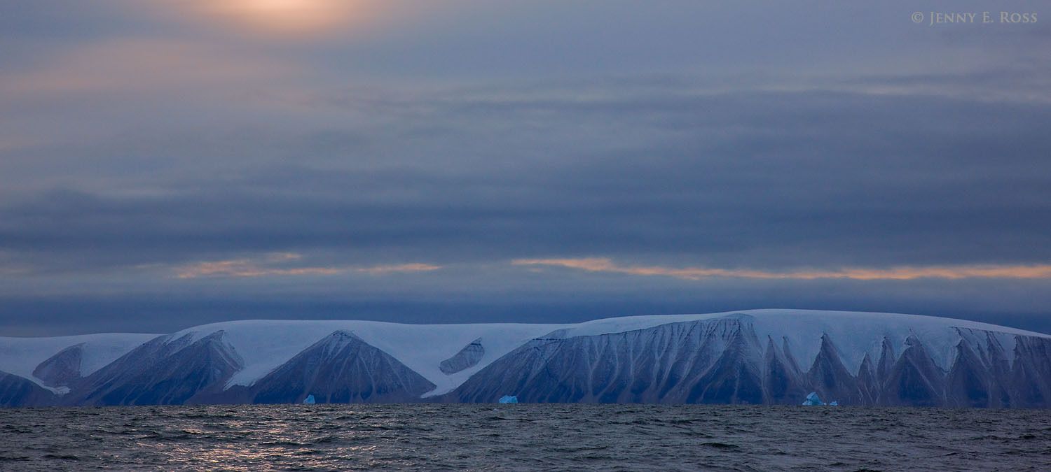 The northern portion of snow-capped Qeqertarsuaq (Herbert Island) in Murchison Sund, Baffin Bay, Northwest Greenland. Even at mid-day, in October the sun is low in the sky.