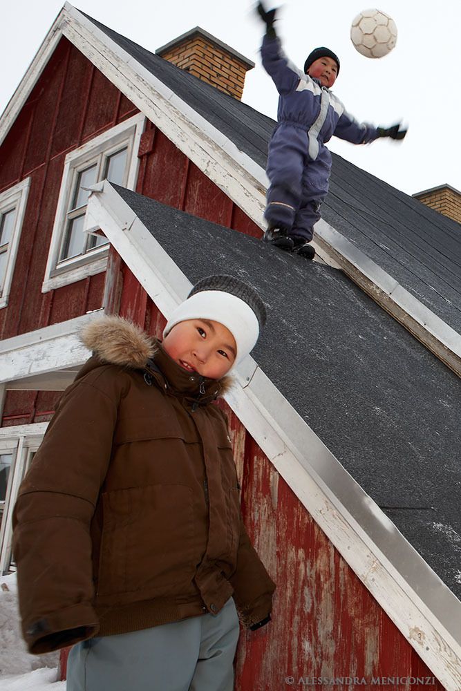 Inuit children playing with a ball in the village of Tasiilaq, southeast Greenland.
