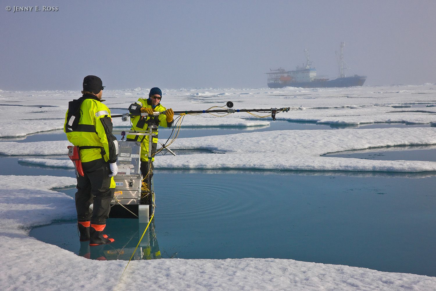 Norwegian Polar Institute geophysicists Dr. Mats Granskog and Dr. Stephen Hudson use several scientific devices mounted on a portable sled to make measurements relating to the absorption and reflection of solar energy by various forms of Arctic sea ice. The scientists collected data during transects across a large floe of sea ice in the Arctic Ocean as part of NPI's 2012 "ICE" (Ice, Climate, and Ecosystems) expedition. The areas of water in the photograph are shallow melt ponds of varying depth on the surface of the ice floe. The NPI ship RV Lance was attached securely to this particular floe of ice, and the vessel moved with the floe as the ice floated freely in the ocean, for the duration of various on-ice research activities in July-August 2012. Scientific research on arctic sea ice, central polar basin, Arctic Ocean