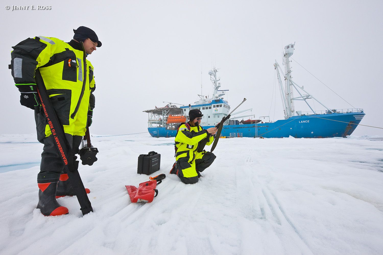 Norwegian Polar Institute sea ice scientists Dr. Christina Pedersen and Dr. Dmitry Divine prepare to deploy research equipment on a large floe of sea ice in the Arctic Ocean during NPI's 2012 "ICE" expedition. The NPI ship RV Lance was attached securely to this particular floe of ice, and the vessel moved with the floe as the ice floated freely in the ocean, for the duration of the on-ice research activities in July-August 2012. In the photograph Dr. Pedersen is loading a rifle that the scientists will have ready at all times for protection from polar bears while they are working on the ice. Scientific research on arctic sea ice, central polar basin, Arctic Ocean