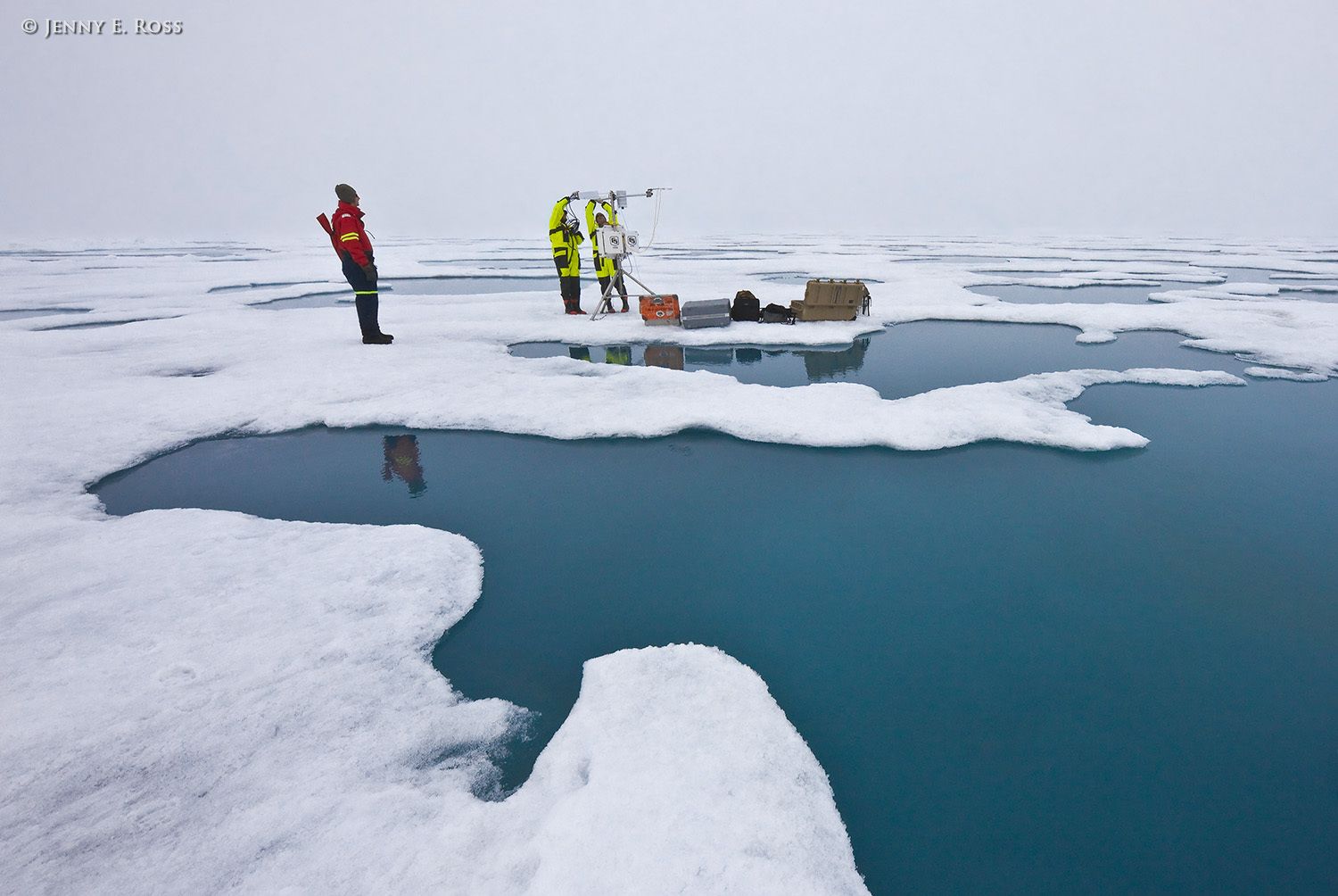 Norwegian Polar Institute scientists Dr. Mats Granskog and Dr. Stephen Hudson deploy research equipment on a large floe of sea ice in the Arctic Ocean during NPI's 2012 "ICE" (Ice, Climate, Ecosystems) expedition in July-August 2012. They are setting up a portable weather station that operated automatically and collected data throughout the expedition. Jens Ehn, a scientist affiliated with the University of Manitoba, functioned as an armed polar bear guard while his colleagues worked on the ice. Scientific research on arctic sea ice, central polar basin, Arctic Ocean