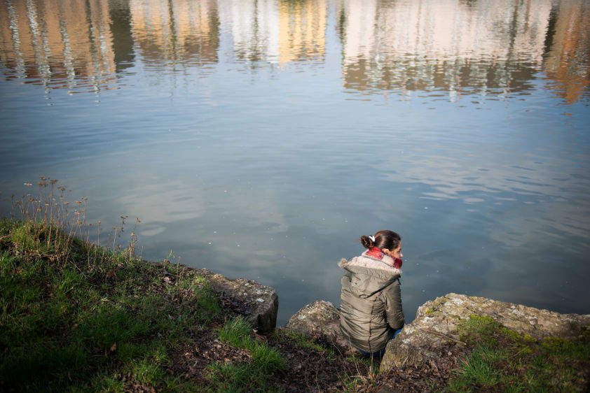 Sarah sits in her favourite spot by the river in a German town where she moved after being released from Islamic State (IS) captivity in Iraq.
