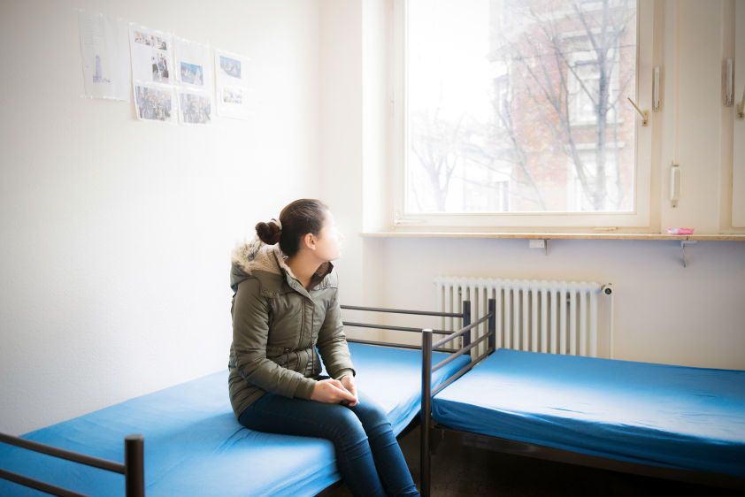 Sarah sits on a bed in an apartment in a German town where she moved after being released from Islamic State (IS) captivity in Iraq.