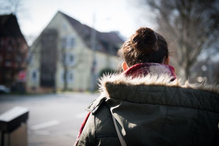 Sarah walks along a street in a German town