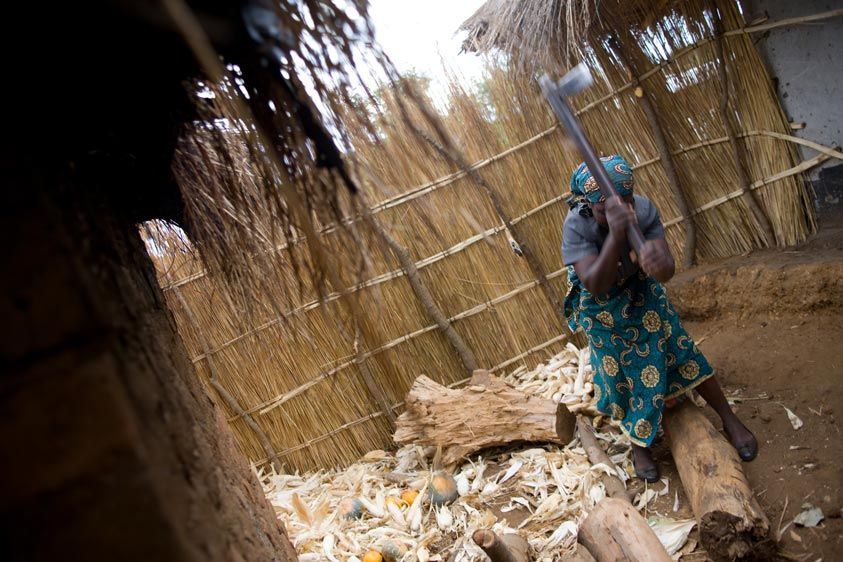 Women are responsible for household needs as well as maintaining their VSL activities. Lucy chops wood for cooking and heating. Chores