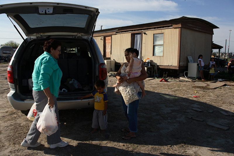 Mary brings groceries to Rosa, who lives with her children in trailer home sectioned off for four families. 1img_2375