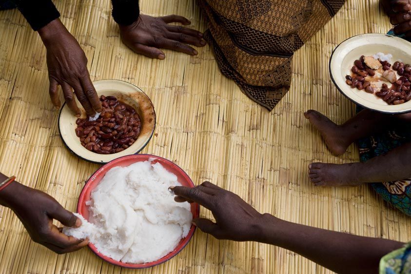 The Namirzi group shares a meal of N'sema (corn meal) and beans. Fortify