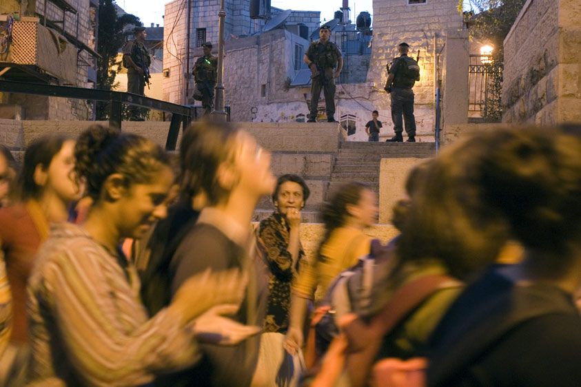 A settler march storms through the Arab Quarter of Jerusalem's Old City under the watch of the Israeli military.  The Palestinian population was placed under curfew to avoid confrontation between the two groups. 1pal_sttlrrlly_05_06
