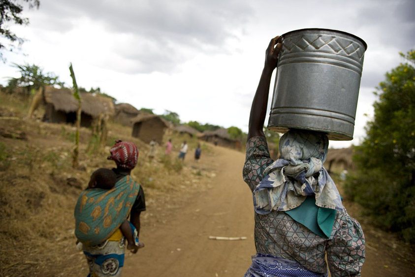 Lucy carries water home from the communal well. At least once a day