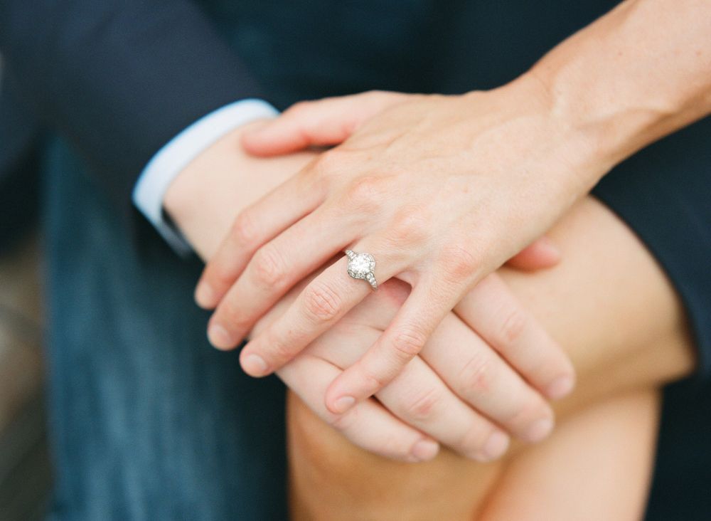 Detail of engaged couples hands with a diamond ring