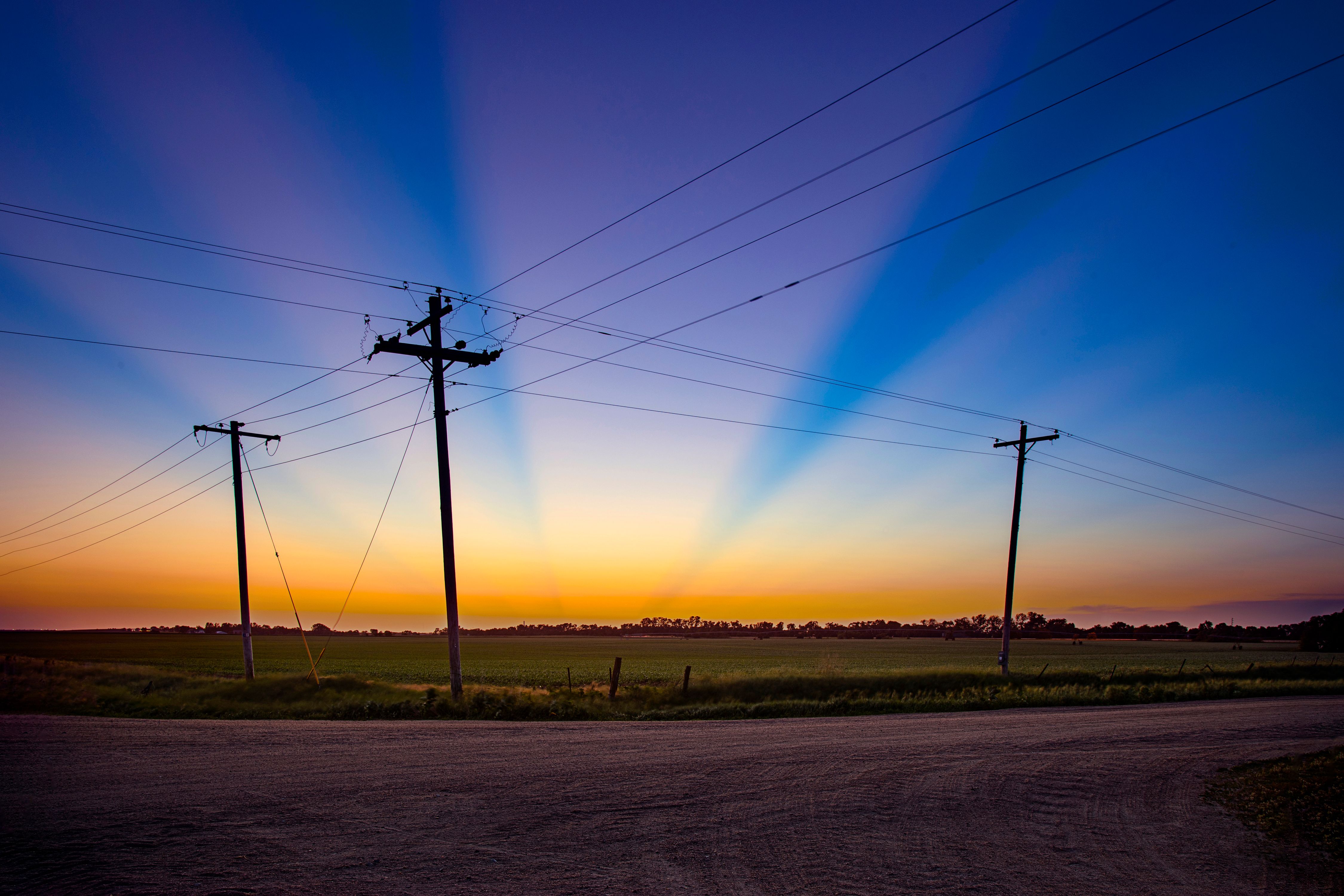 ThreeTelephonePolesSunRays.jpg