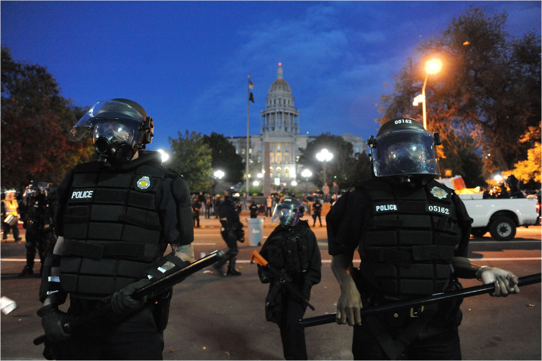 Denver Police officers in full riot gear block Broadway with the state Capitol in the background. 1occupy30b