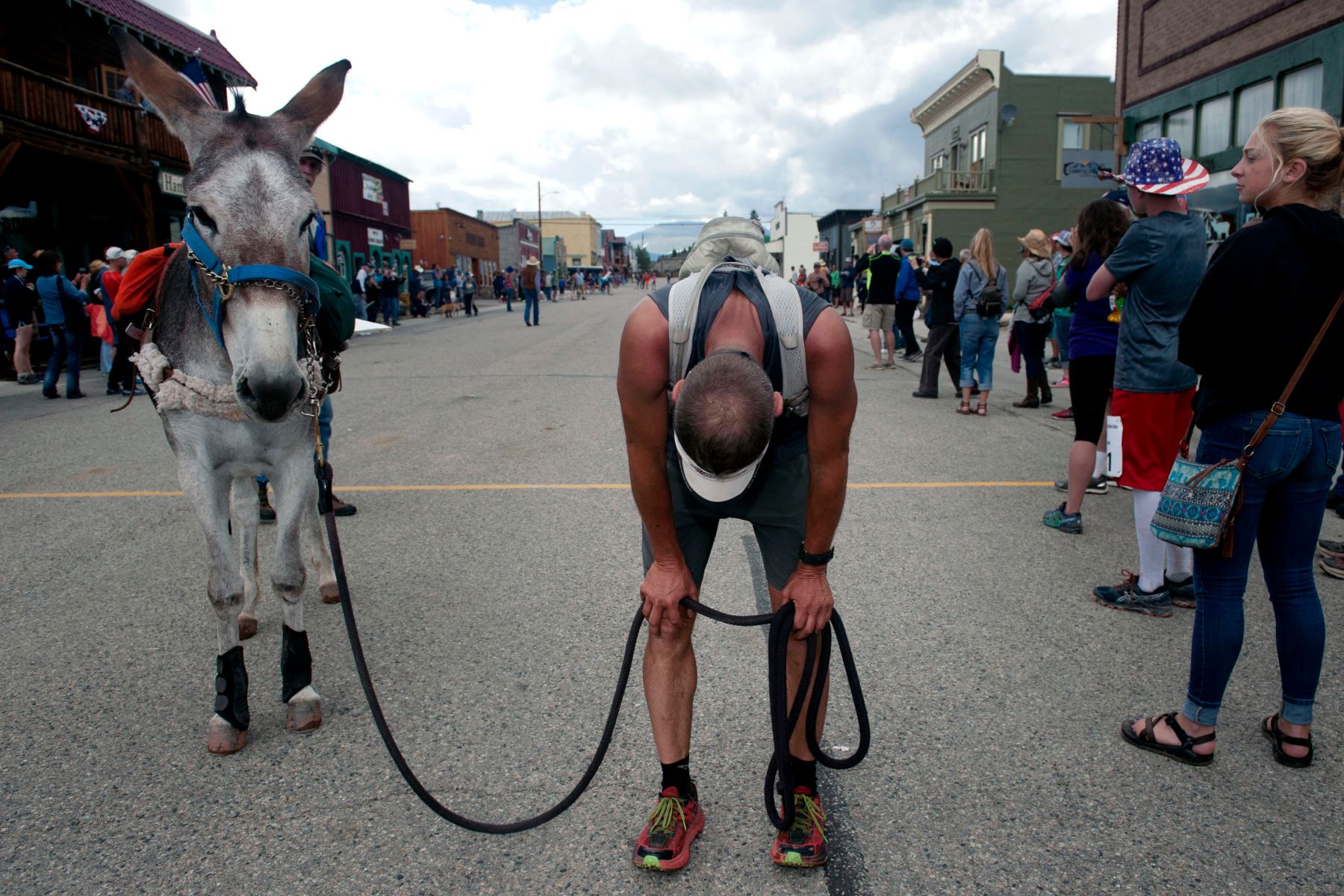 Kirt Courkamp of Pine, Colorado bows his head in exhaustion after winning  the Pack Burro Race during the 69th Annual Burro Days in Fairplay, Colorado on July 30, 2017. Courkamp and his burro Mary Margaret, finished the course in under six hours. 1burro_days_2017395seqn_
