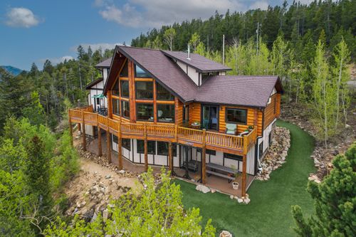 A drone photo showing a mountain home on the side of a steep hill Drone Real Estate - A Colorado Mountain Home