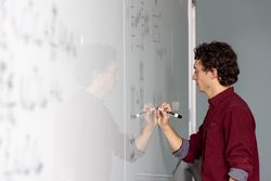 A datsa scientist making calulations on a whiteboard. White Board Calculations