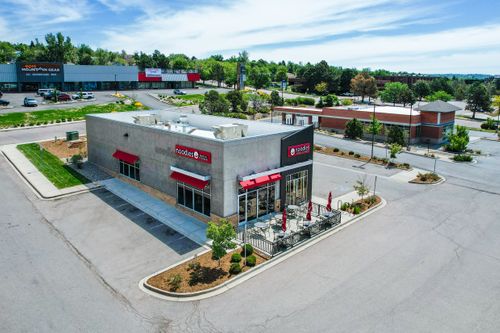 A drone photo looking down on a commercial restaurant surrounded by vehicle parking spaces. Drone photography used for commercial real estate marketing. Commercial Real Estate Drone Photography