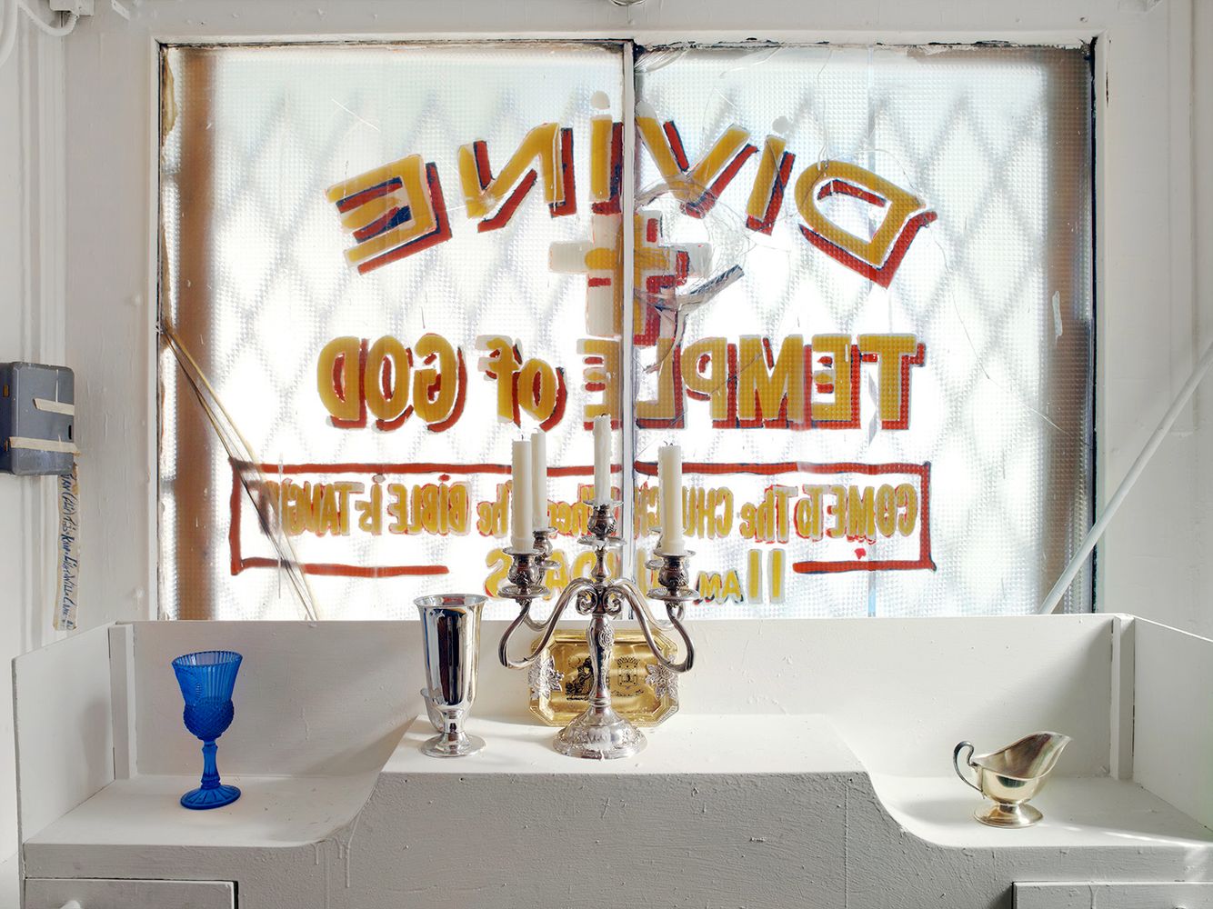 A sparsely adorned alter built behind a hand painted storefront window. Church closed in 2007 Alter, Divine Temple of God Spiritual Church, Chicago 2006