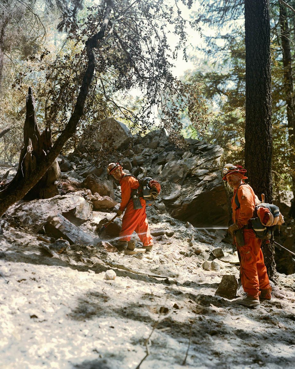 Inmate crews work alongside wildland firefighters often performing the same 16 hour shifts expected of their counterparts.  The Chalk Fire spread through a remote area near Mount Shasta that caused the evacuation of a number of small communities outside of Burney.  I was granted media access through CalFire and couldn’t believe the weight of the camera equipment’s effect on sliding through ash in 100-degree heat in the same orange NOMEX suit as the personnel. Ernest & Rodney, Inmate Crew, 2009 Chalk Fire, California-Day 13