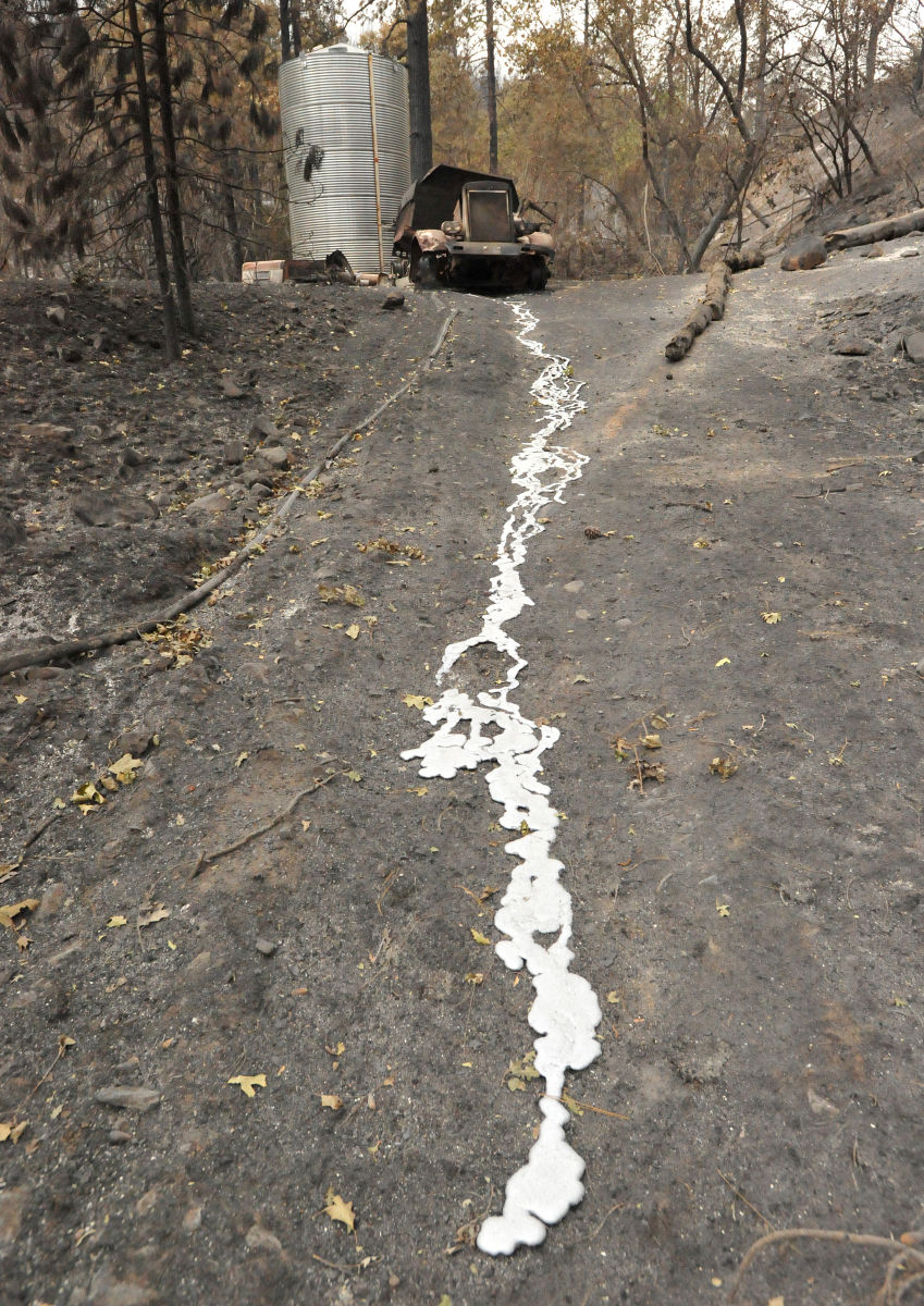 Melted metal flows from a burned out truck down a hill in a residential neighborhood.