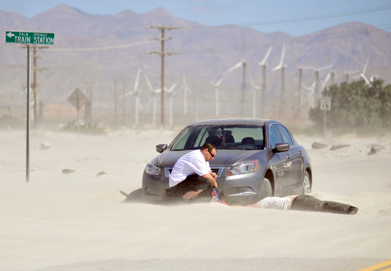 WEATHER: High winds paralyze a car as sand dunes take over a road in Palm Springs.