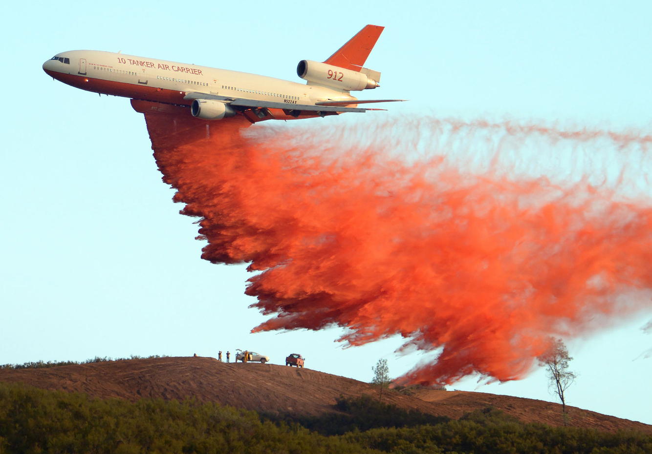 An air support tanker drops fire retardant on a ridge