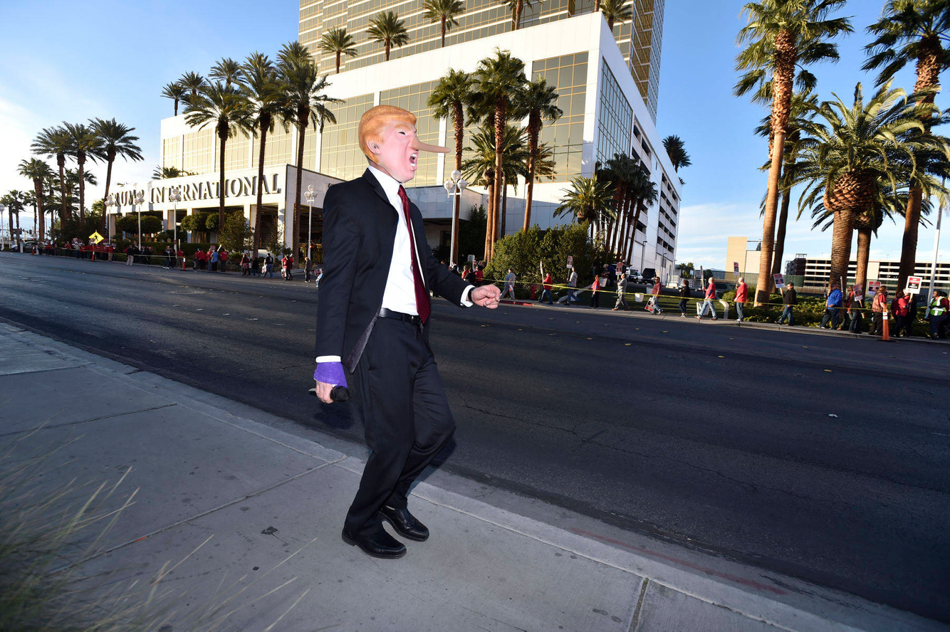 An anti-Trump protesters sings and dances in front of the Trump Hotel in Las Vegas.