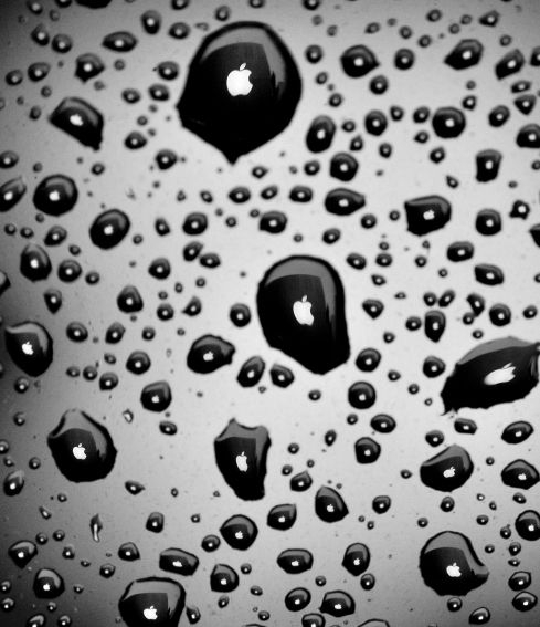 WEATHER: Raindrops refract a sign in front of an Apple store